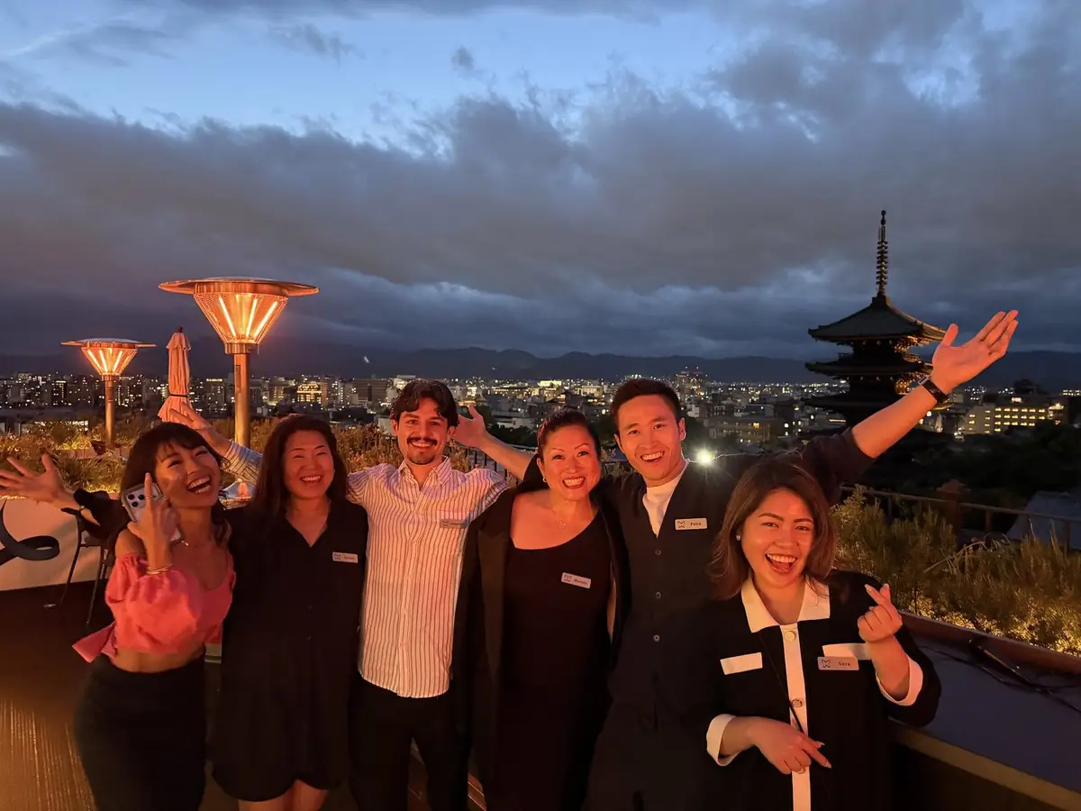 The team on the K36 rooftop at dusk, a pagoda and Kyoto behind them