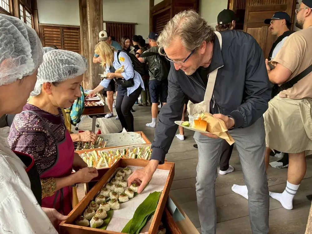 Guests in hairnets at a hands-on food workshop in a wooden hall