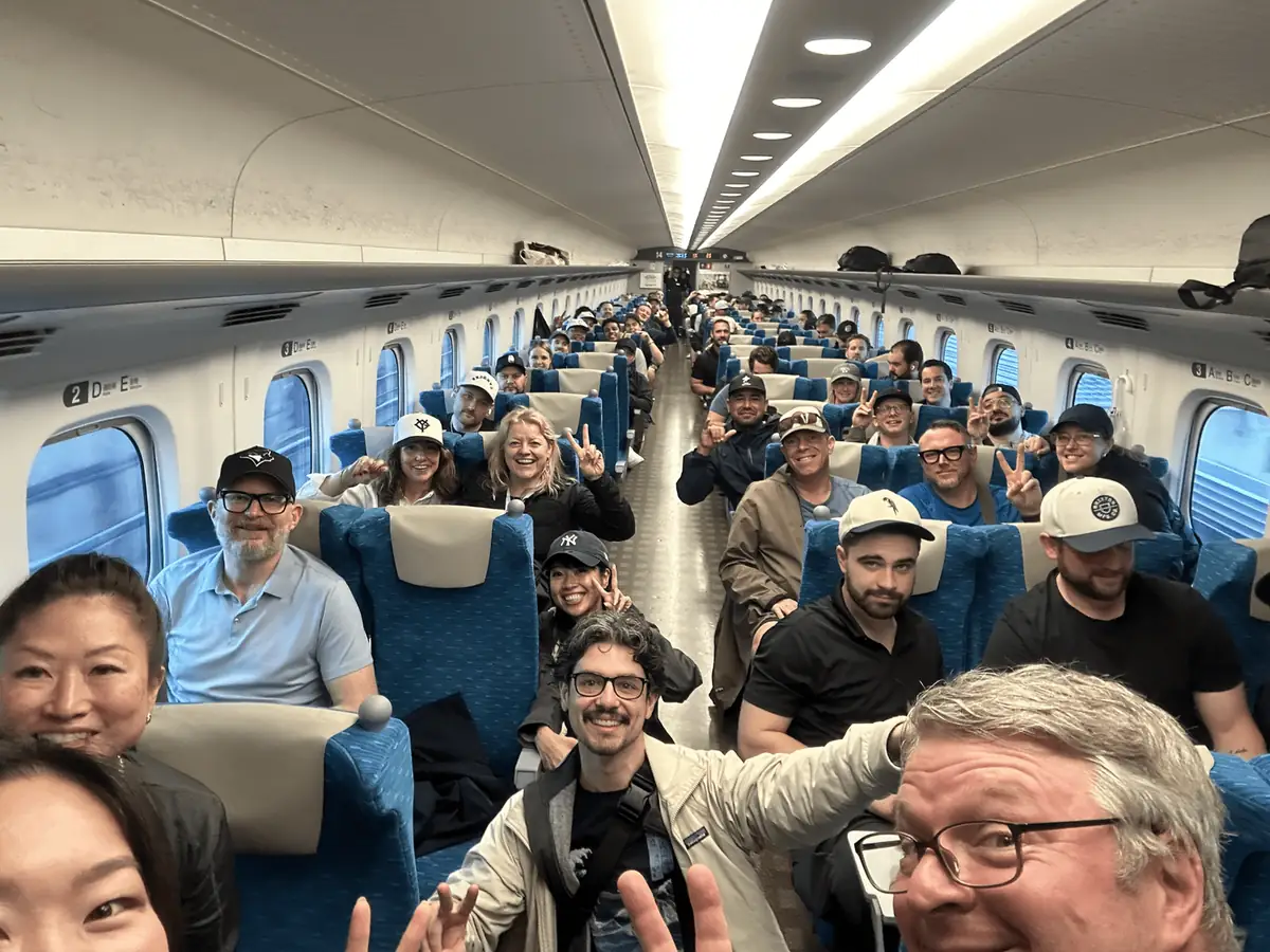A bullet train car full of guests, smiling for the camera