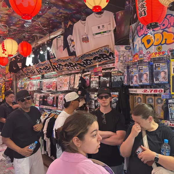 A team inside a packed Don Quijote store, under red lanterns